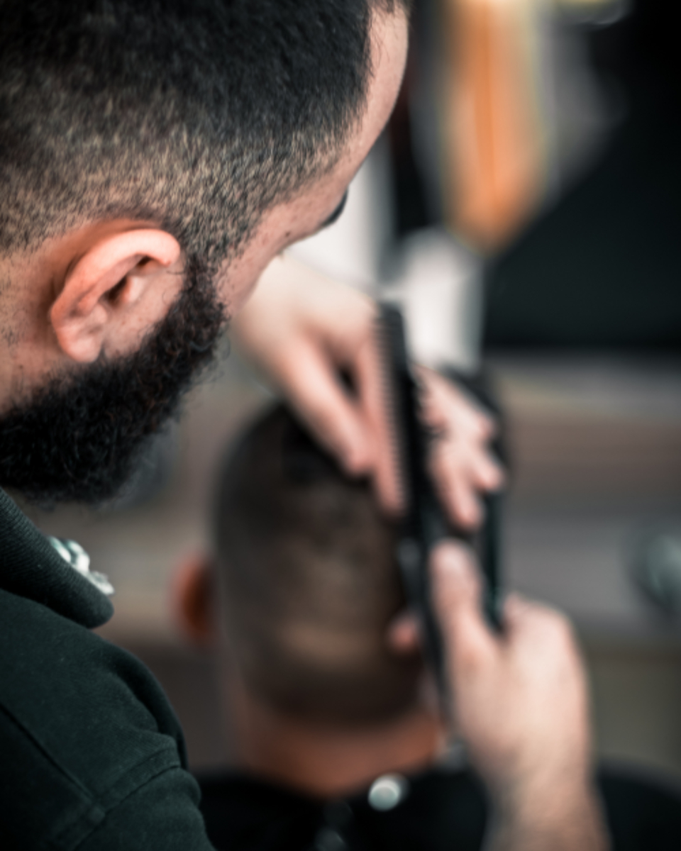 Barber giving a short buzz cut with clippers