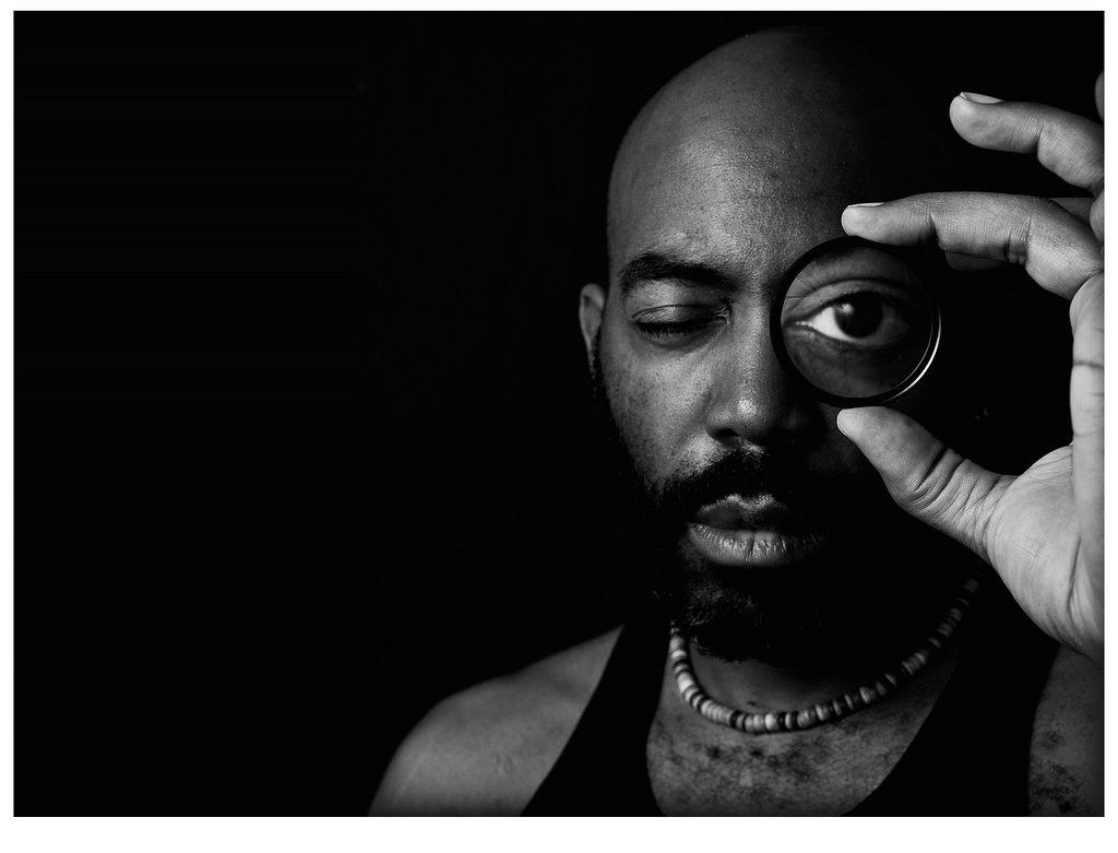 A confident bald man with a neatly groomed beard, looking distinguished rather than older