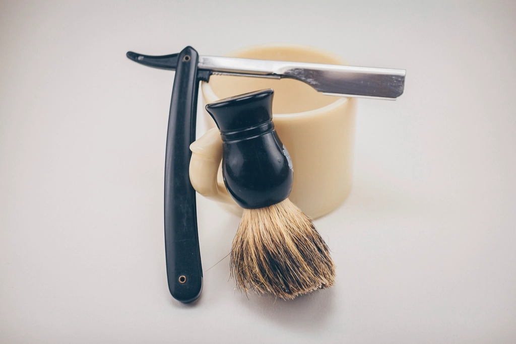 A razor, shaving brush and lather mug — a classic wet-shave kit