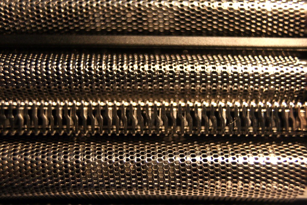 Extreme close-up of a foil electric head shaver's cutting foils and blades
