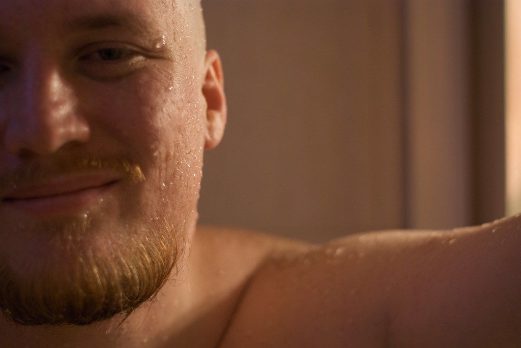 Man with a freshly shaved wet bald head after showering, water droplets on his scalp